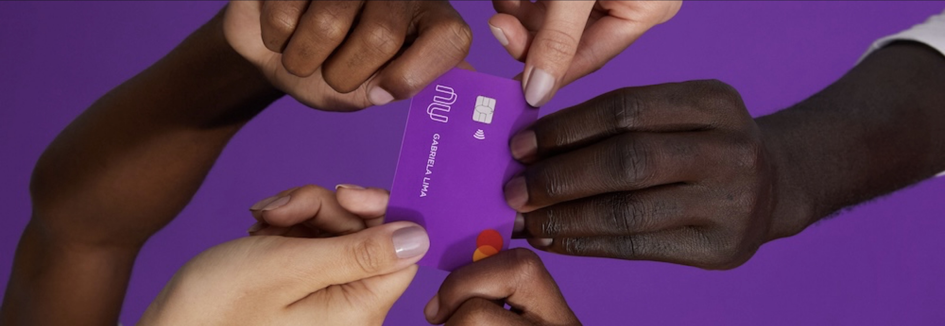 Nubank card being handed between hands